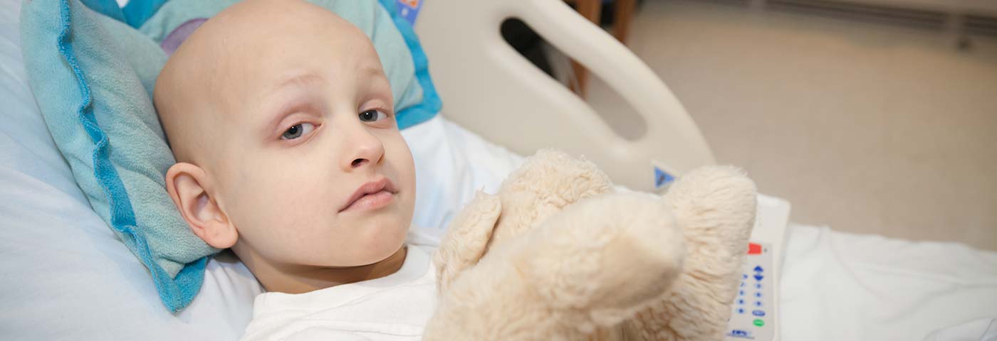 Girl in hospital bed with stuffed animal